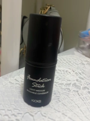 Foundation Stick från KICKS - Foundation Stick från KICKS i svart hylsa. Ger lätt till medium täckning och är enkel att bygga upp. Perfekt för att jämna ut hudtonen och skapa en naturlig bas. Smidig att ta med i väskan tack vare den kompakta formen.