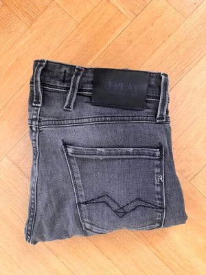 Grå jeans från Replay - Grå Replay Anbass jeans i W29/L30. Slim fit med clean tvätt och klassiska Replay-detaljer. Väldigt fint skick och perfekt för grisch/preppy-stil.