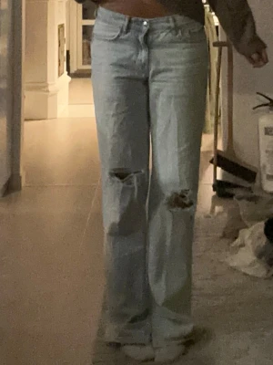 Baggy jeans  - Ljusa baggy/straigt jeans ifrån Gina, med hål å slitningar med side slit, storlek 32,