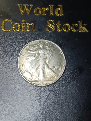 Amerikansk silverhalvdollar 1918 med plast cylinder och serienummer  - Säljer ett samlarmynt från USA, en Walking Liberty Half Dollar från 1918 i silver. Myntet har motiv av Lady Liberty på ena sidan och en örn på andra sidan. Perfekt för dig som gillar numismatik eller vill utöka din myntsamling.