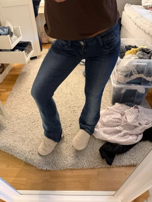 Mörkblå bootcut jeans - Säljer ett par mörkblå bootcut jeans med klassisk femficksdesign och normal midja. Jeansen har en lätt utsvängd passform nedtill och är tillverkade i stretchigt denimtyg för extra komfort. Perfekta för en avslappnad och trendig look.