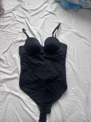 Svart body med vadderade kupor - Snygg svart body med öppen rygg. Jättefin men kommer inte till användning längre❣️pris kan diskuteras