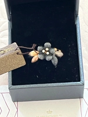 Ole Lynggaard blomster ring med diamanter  - Ole Lynggaard blomster ring gjord av sterling silver samt 18k guld med naturliga diamanter helt ny oanvänd. Säljes inte mer i butik samlarföremål! Storlek kan justeras. .size 61 55 53 finns tillgängliga at the moment. 