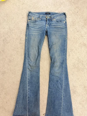 True religion jeans Joey model  - Jag säljer ett par mörkblåa med ljusa detaljer på benen och visa gula syda detaljer. Haft dem i ungefär 1 år. Väldigt bra skick. Inget trasigt längst ner på byxorna. ⚠️pris kan diskuteras⚠️