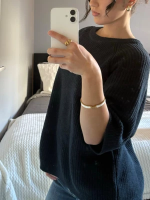 Mörkblå oversized stickad tröja - Säljer en mörkblå oversized stickad tröja med rund halsringning och trekvartsärmar. Tröjan har en ribbad struktur och är gjord i ett mjukt material som känns skönt mot huden. Perfekt för lager på lager och enkel att styla till jeans eller kjol.