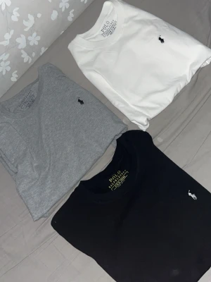 3-pack Polo Ralph Lauren t-shirts - Säljer ett 3-pack klassiska t-shirts från Polo Ralph Lauren i färgerna svart, vit och grå. Alla har rund hals, korta ärmar och den ikoniska broderade loggan på bröstet. Perfekta basplagg i mjuk bomull som funkar till allt.