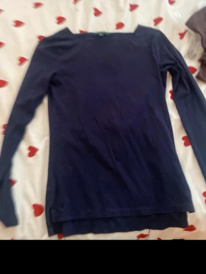 Mörkblå långärmad tröja Lauren Ralph Lauren - En enkel och stilren mörkblå långärmad tröja från Lauren Ralph Lauren. Tröjan har rund halsringning och är tillverkad i ett mjukt, tunt material som passar perfekt till lager på lager. Klassisk passform och diskret design.