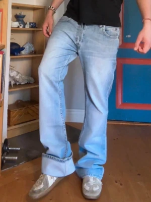 Ljusblå bootcut jeans med modellen Lee Denver - Säljer ett par ljusblå jeans med bootcut passform från Lee. Jeansen har klassisk femficksdesign, låg midja och slitna detaljer för en avslappnad look. Perfekta för dig som gillar ett par riktigt trevliga bootcut jeans i lite retrostil. Totala längden är 111.5 cm, midjan är 42cm och ben öppningen 25 cm, hör av er vid frågor o funderingar!!