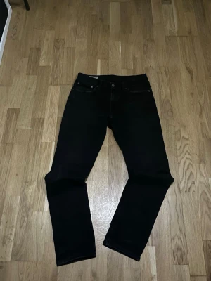 Levis 511 - Säljer ett par svarta jeans med slim passform och klassisk femficksdesign. Jeansen har normal midja och är tillverkade i ett kraftigt denimtyg. Perfekta för dig som gillar en enkel och stilren look. W31 L32