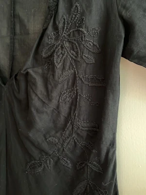 Blus i bomull - Svart blus i bomull köpt secondhand, tvättad och aldrig använd av mig. Fin brodyr (se bild 2). Passar storlek 34-36, ev. liten 38.