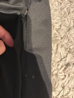Svart handväska från HUGO - Snygg svart handväska från HUGO med en tydlig röd logga på insidan. Väskan har dragkedja och är tillverkad i ett tygmaterial som känns slitstarkt. Perfekt för dig som vill ha en stilren och enkel accessoar.