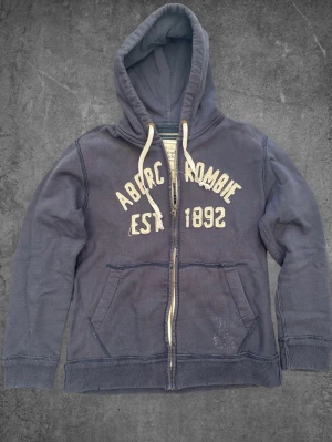 Vintage Abercrombie And Fitch zip hoodie - Blå -  Vintage Abercrombie And Fitch zip hoodie - Blå   Storlek: M Skick: Mycket bra Hör gärna av dig om du har några frågor, vill ha mått eller fler bilder!