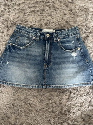 Blå jeanskjol från Stradivarius - Säljer denna snygga blå jeanskjol från Stradivarius!💗Kjolen har inbyggda shorts och är endast använd fåtal gånger, men säljer då den inte kommer till användning. Skriv gärna för fler bilder eller prisförslag💗