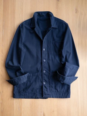 Navy Chore Jacket, size S - Stilren mörkblå overshirt i bomull med klassisk krage och tre framfickor. Knäpps med fyra knappar framtill och har uppvikta ärmar för en avslappnad look. Perfekt att bära över en t-shirt eller hoodie för en trendig lager-på-lager stil.