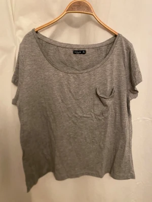 Grå t-shirt - Har ficka på framsidan. Storlek XL. Inga fläckar eller hål