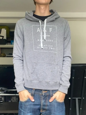 Abercrombie & fitch hoodie - En snygg grå hoodie från a&f i storlek L, sitter som xs/s. Han på bilden är 179. Fint skick. Har du några frågor? Fråga på