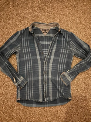 Blå rutig Tommy Hilfiger skjorta - Tjenare! Säljer en blå rutig långärmad skjorta med märke Tommy hilfiger den är storlek S o sitter rätt bra på mig som e 185 o lite smalare men riktigt go skjorta.