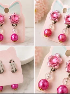Rosa blomformade clip-on örhängen - Söta örhängen med clip-on fäste i form av rosa blommor med glittrande detaljer. Hängande pärlor i rosa och transparent ger ett lekfullt och trendigt uttryck. Perfekta för dig som vill ha örhängen utan hål och gillar färgglada accessoarer för barn.
