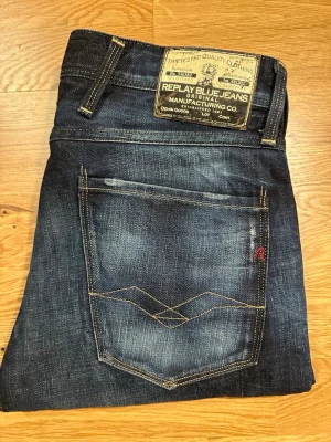 Mörkblå Replay Fc Barcelona jeans  - Snygga mörkblå jeans från Replay med klassiska slitningar och kontrastsömmar. Modellen har fem fickor, läderpatch bak och detaljer som röd logotyp på bakfickan. Jeansen är tillverkade i denim och har Anbass passform. Just dumma jeansen är speciella för att det är FC Barcelona Replay, de är riktigt svåra att få tag på därav priset så om du vill ha ett par Replay jeans som sticker ut från mängden är dessa jeans perfekt för dig.