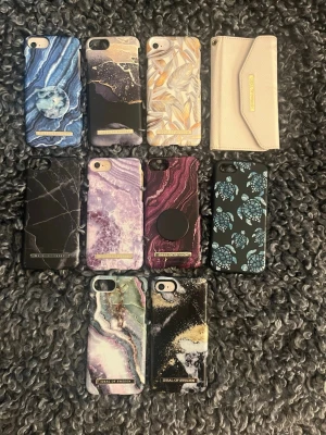 10 snygga mobilskal i olika mönster från ideal of Sweden  - 25kr styck viss eller alla för 200kr för iPhone 8, alla med unika mönster som marmor, blad, abstrakt konst och ett beige plånboksfodral. Färgerna varierar mellan blått, svart, lila, grönt, guld och beige. Flera skal har detaljer i guld och vissa har märkningen 'iDeal of Sweden'.