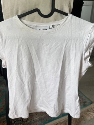 Vit basic t-shirt från Weekday - Säljer en knappt använd vit t-shirt från Weekday med korta ärmar. Den sitter tajt mot kroppen💗💗