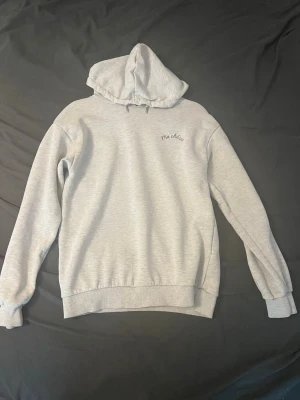 Ljusgrå hoodie med tryck Ma Chérie - Säljer en ljusgrå hoodie i 158/164 (xs-s) med huva och trycket 'Ma chérie' på bröstet och ryggen från gina. Har vissa imperfektioner som visas på bilderna men är fortfarande i bra skick. På ryggen finns även ett hjärta med pil. Hoodien har ribbade muddar vid ärmar och nederkant. Perfekt för en chill och avslappnad stil.