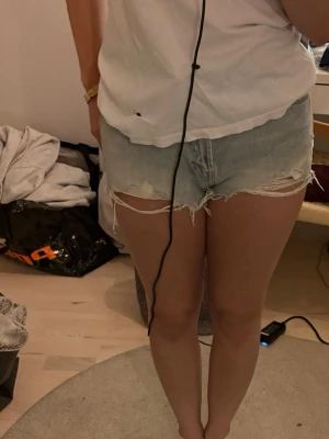 Ljusblå jeansshorts med fransig kant - Säljer ett par blåa shorts med snygg tvätt från Zara med frasig kant och fem fickor. Säljer de för de blivit för stora och använder inte längre 🤗