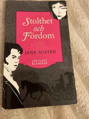 Stolthet och fördom lättläst klassiker - Säljer boken 'Stolthet och fördom' av Jane Austen i lättläst version. Omslaget är svart och rosa med illustrationer av karaktärer och häst och vagn. Perfekt för dig som vill läsa en klassiker i enklare format. Utgiven av LL-förlaget.