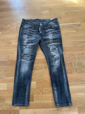 Dsquared2 jeans - Mörkgråa dsquared2 jeans med färgstänk och slitna detaljer i bra skick. Säljer pga att de är för små(storlek 54 men väldigt små i storleken) skriv gärna om funderingar på storlek eller fler bilder, priset går att diskutera vid snabb affär✅
