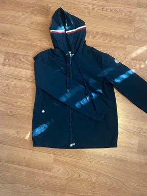 Mörkblå Moncler Windbreaker - En moncler windbreaker i mörklblå färg. Knappast använd. Storlek S/1. NFC tag till riktiga moncler hemsidan. Hör av er för mer frågor!🇫🇷