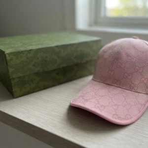 Rosa keps från Gucci med monogram - Säljer en snygg rosa keps från Gucci med klassiskt GG-monogram i hela tyget.  Kepsen är endast testad säljes då den inte passar mitt huvud etiketter och orginalbox medföljer 