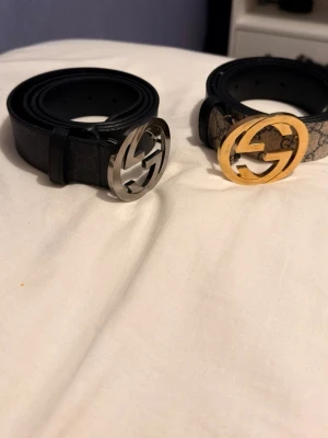 250 per bälte  - Säljer två snygga , ett i svart skinn med silverfärgat -spänne och ett i beige/brunt mönstrat material med guldfärgat -spänne. Perfekta accessoarer för att lyfta din outfit.