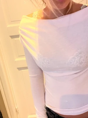 Offshoulder tröja - En långärmad ljusrosa offshoulder tröja i tunt stickat material. Har ett litet hål på baksidan av tröjan som knappt syns.