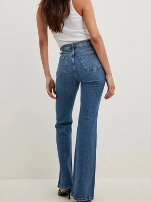 Blå bootcut jeans med medium midja - Snygga blå bootcut jeans med medium midja och klassiska bakfickor. Jeansen har en tidlös tvätt och raka ben som slutar i en lätt utsvängd passform. Perfekta att styla med sneakers eller boots för en trendig look.