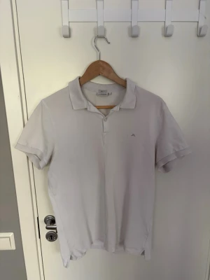 Vit pikétröja från J.Lindeberg - Klassisk vit pikétröja från J.Lindeberg i slim fit-modell. Tröjan har korta ärmar, krage och knappar framtill. Tröjan är i ett mycket gott skick och har inga defekter eller likande, hör av er vid frågor!