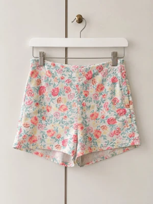 Blommiga shorts från H&M Divided - Säljer ett par söta blommiga shorts från H&M Divided i storlek 38. De har en ljus bas med rosa, gula och blå blommor, normal passform och är tillverkade i en mjuk bomullsblandning med lite stretch. Perfekta för varma dagar!