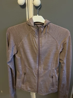 Ljuslila träningsjacka  -  ljuslila träningsjacka från H&M Sport med dragkedja framtill, huva och två fickor med dragkedja. 