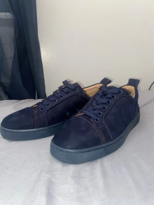 Mörkblå mocka sneakers - Snygga mörkblå sneakers i mocka med matchande blå skosnören och sula. Skorna har en klassisk låg profil och diskreta sömmar. Insidan är ljusbeige och de har en enkel, stilren design som passar till det mesta.