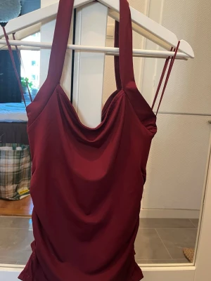 Rött halterneck linne  - Superfint stretchigt linne i fin vinröd färg. Aldrig använt! 