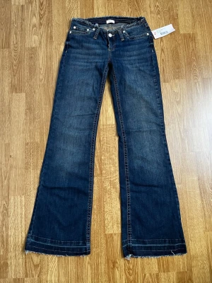 Nya lowwaist bootcut Nelly jeans - Helt nya med prislapp, mörkblå lågmidjade Nelly jeans i storlek 34