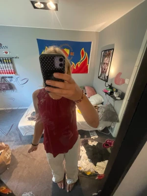 Vinröd spetsdetaljerad linnetopp - Säljer en vinröd ärmlös linnetopp med fina spetsdetaljer vid axlarna och halsen. Den är från HM som sitter väldigt fint på kroppen och är ganska tunn i materialet. Köpte den för ungefär 250 kronor 