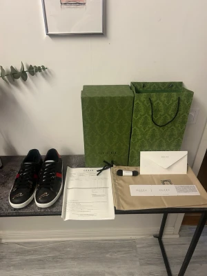Gucci Ace sneakers med tigerprint - Snygga Gucci Ace sneakers i svart läder med klassiska röda och blå ränder på sidorna. Skorna har ett coolt tigertryck framtill och vita sulor. Perfekta för dig som vill sticka ut med exklusiva detaljer och lyxig känsla. Pris kan diskuteras 🙌🏼 lägsta jag går är 1899!🙌🏼🤩