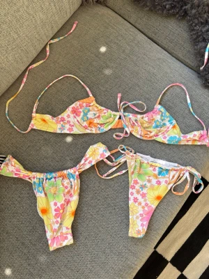 Blommig bikini  - Säljer en bikini med blommigt mönster som är som ny! Kommer med två underdelar i olika modeller💕