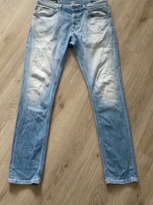 Dondup George Jeans - Säljer ett par ljusblå skinny fit jeans med tvättade detaljer framtill. Klassisk femficksmodell med dragkedja och knapp i midjan. Jeansen har en modern passform och är tillverkade i denim med lite stretch för extra komfort. Pris är ej hugget i sten, hör av er för mer info