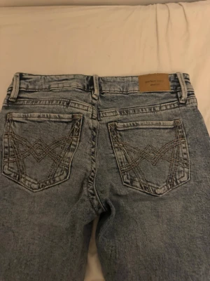 Ljusblå jeans från Perfect Jeans - Säljer ett par ljusblå jeans från Perfect Jeans med snygga detaljerade bakfickor och klassisk femficksdesign. Jeansen har en normal passform och är tillverkade i bomull för en bekväm känsla. Perfekta till din vardagsstil!