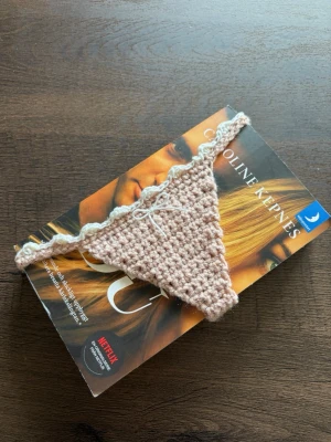 Rosa virkat bokmärke  - Ett bokmärke i form av en trosa med spetskant och en liten rosett framtill 