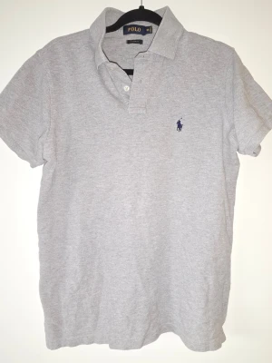 Grå pikétröja från Polo Ralph Lauren - Custom fit-modell som sitter snyggt och avslappnat. Bra skick! 