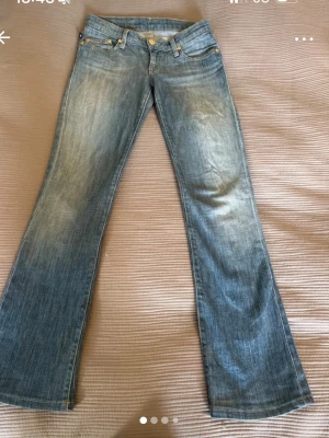 Ljusblå raka jeans Rock & Republic - Säljer ett par ljusblå jeans från Rock & Republic med utsvängda ben. Jeansen har snygga slitningar och kontrastsömmar samt broderade detaljer på bakfickorna. Perfekta för en avslappnad och trendig look. Lite långa på mig som är 161cm