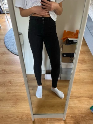 Gina tricot Molly Svarta high waist skinny jeans jeans - Säljer ett par svarta high waist skinny jeans med smal passform och klassisk femficksdesign. Jeansen har knapp- och dragkedjestängning samt sitter tight hela vägen ner till ankeln. De är i Molly-modellen. 