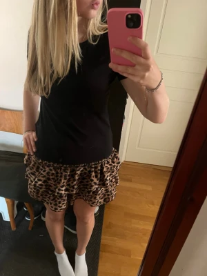 Leopardfärgad kjol - En jättefin leopard färgad volang kjol med insyddashorts. Den är från en marknad i Spanien och har en skön passform.
